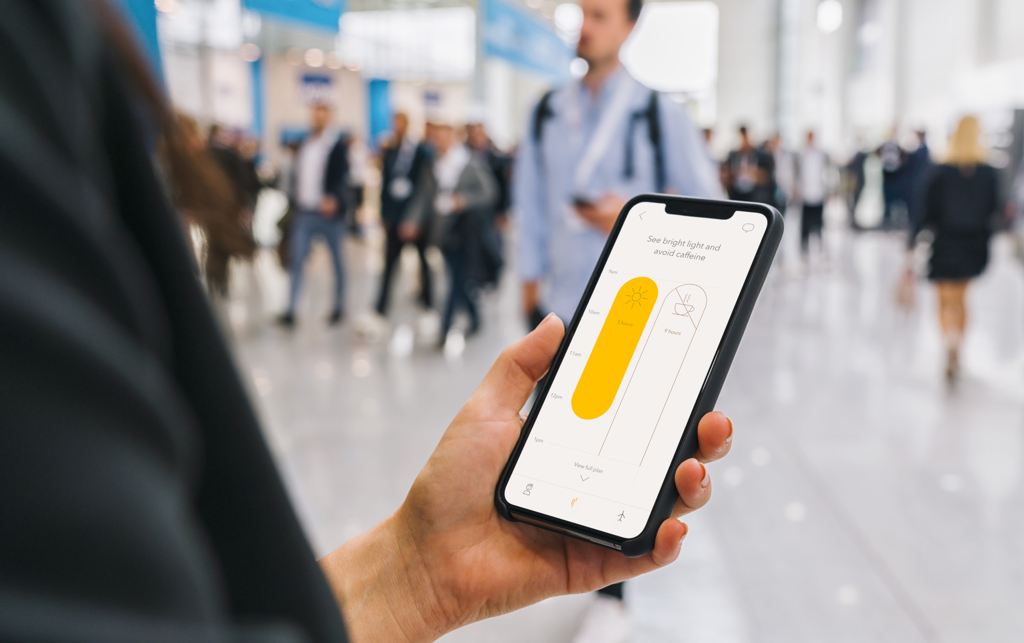 view of phone in female hands with empty screen, with crowd of p